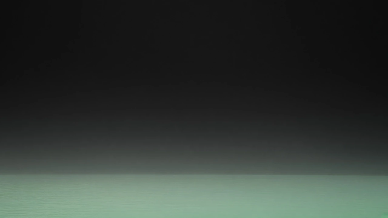 A low band of pale water fading into black.